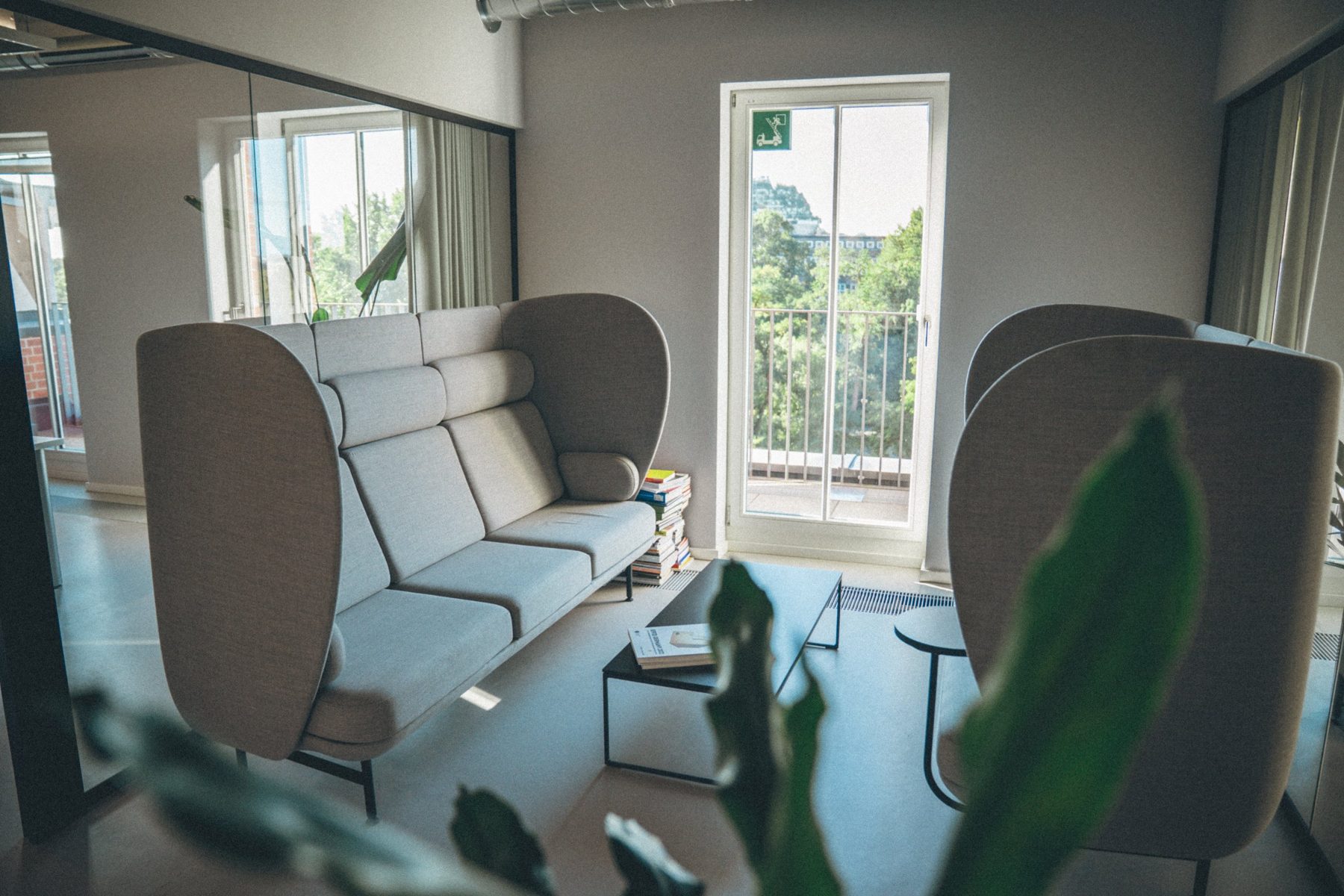 Lounge mit hohen Sofas und Balkontür