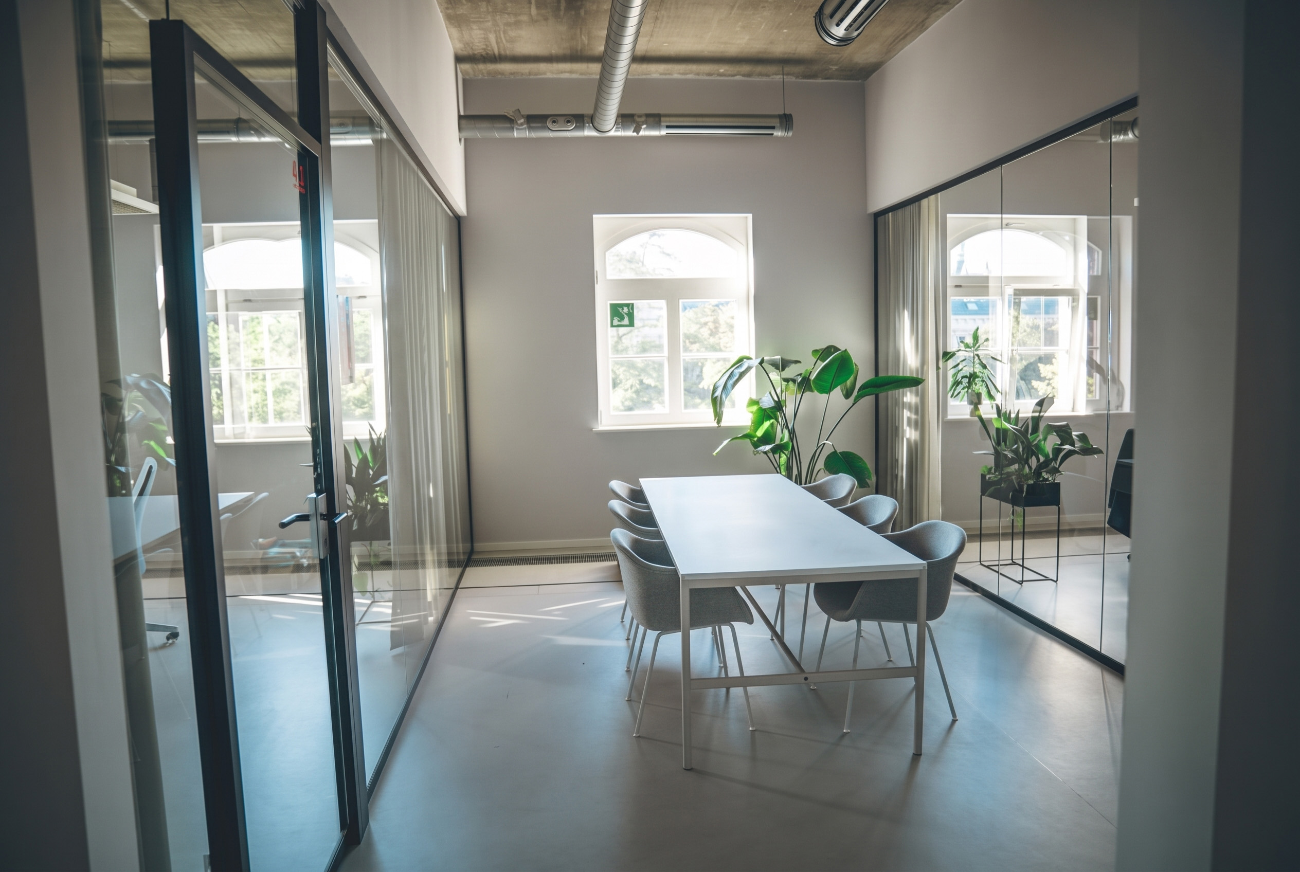 Besprechungsraum mit Rundbogenfenster und Pflanzen